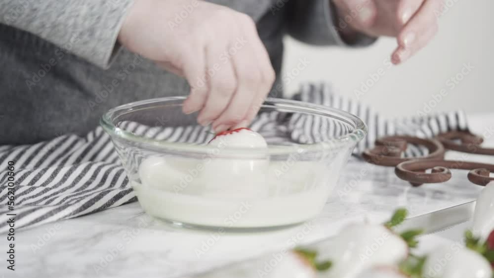 Step by step. Dipping organic strawberries into a bowl with melted chocolate to prepare chocolate covered strawberries. Step by step. Dipping organic strawberries into a bowl with melted chocolate to prepare chocolate covered strawberries.