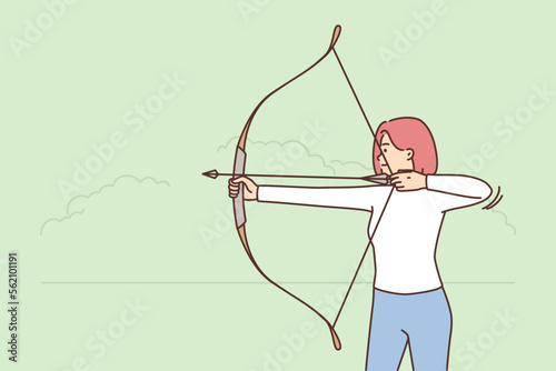 Young woman shoot with bow outdoors