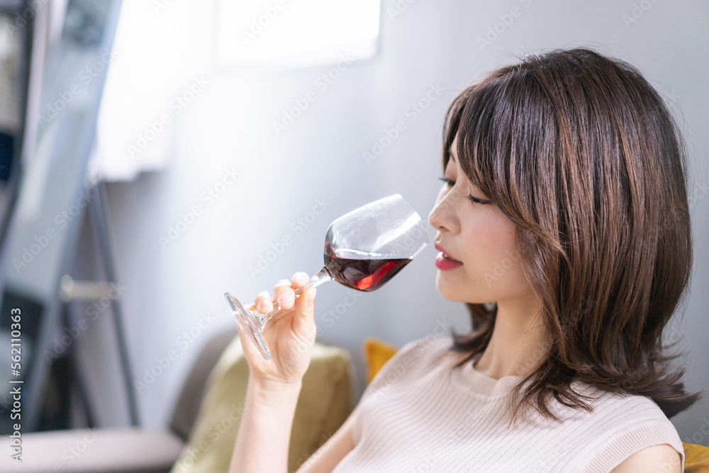家でワインを楽しむ若い女性 家でワインを楽しむ若い女性