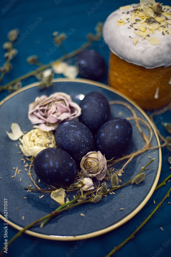 Kulich with sugar glaze .decoration design blue easter eggs lie on a plate with a willow on fabric background. Paska Easter Bread Kulich with sugar glaze .decoration design blue easter eggs lie on a plate with a willow on fabric background. Paska Easter Bread