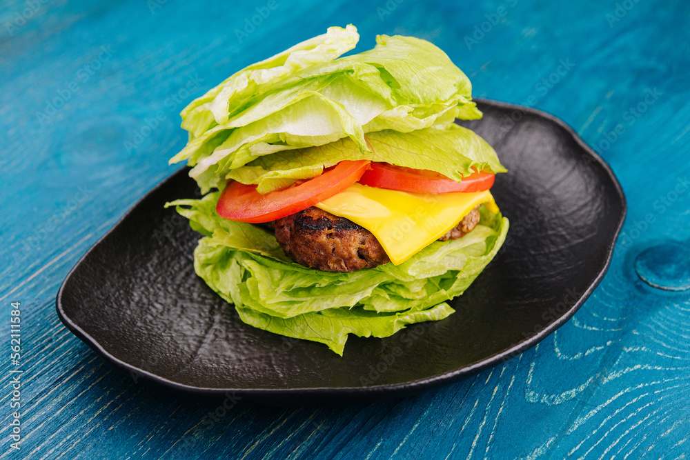 Healthy hamburger wrapped in lettuce - obrazy, fototapety, plakaty 