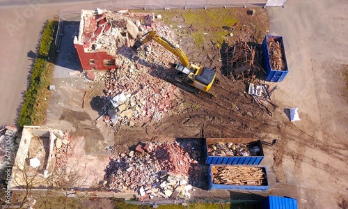 Demolition of a residential building with an excavator, construction work, urban development, aerial view