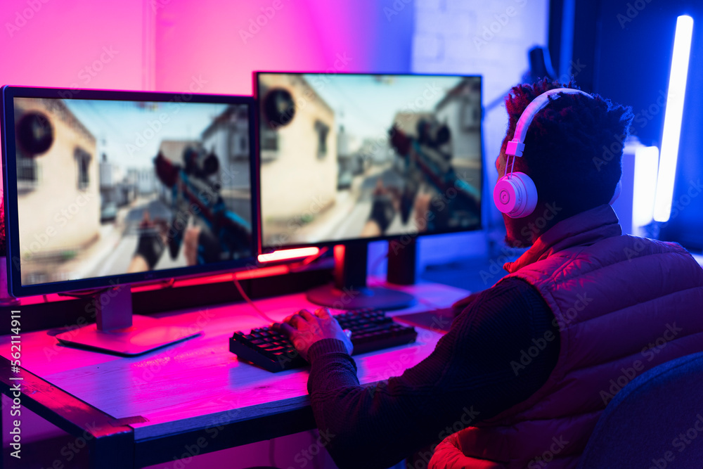Young African man playing video game on computer. Streamer guy sitting at home and plays another match. Young African man playing video game on computer. Streamer guy sitting at home and plays another match.