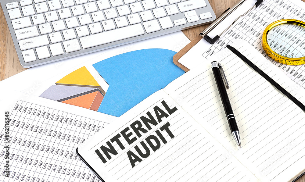INTERNAL AUDIT text on notebook with chart and keyboard INTERNAL AUDIT text on notebook with chart and keyboard