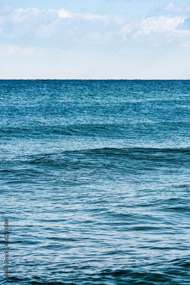 a vertical shot of the serene blue sea High-resolution sea photo with a sentimental vibe.