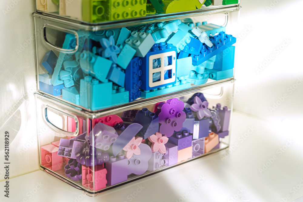 Fototapeta premium Bricks duplo. Bricks sorting by colors in transparent plastic containers. Storage Ideas in nursery. Space organizing at children's room.