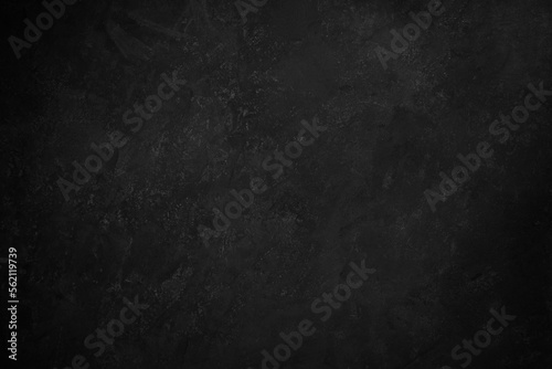 Black concrete background texture with vignetting.