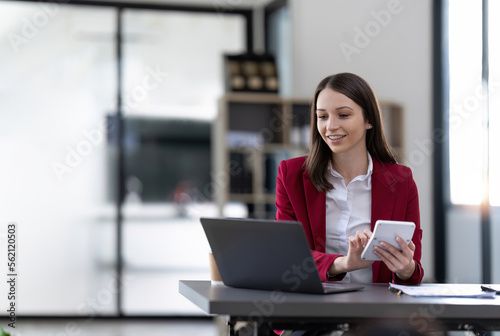 businesswoman using a calculator to check company finances and earnings and budget. Business woman calculating monthly expenses, managing budget, papers, loan documents, invoices © Natee Meepian