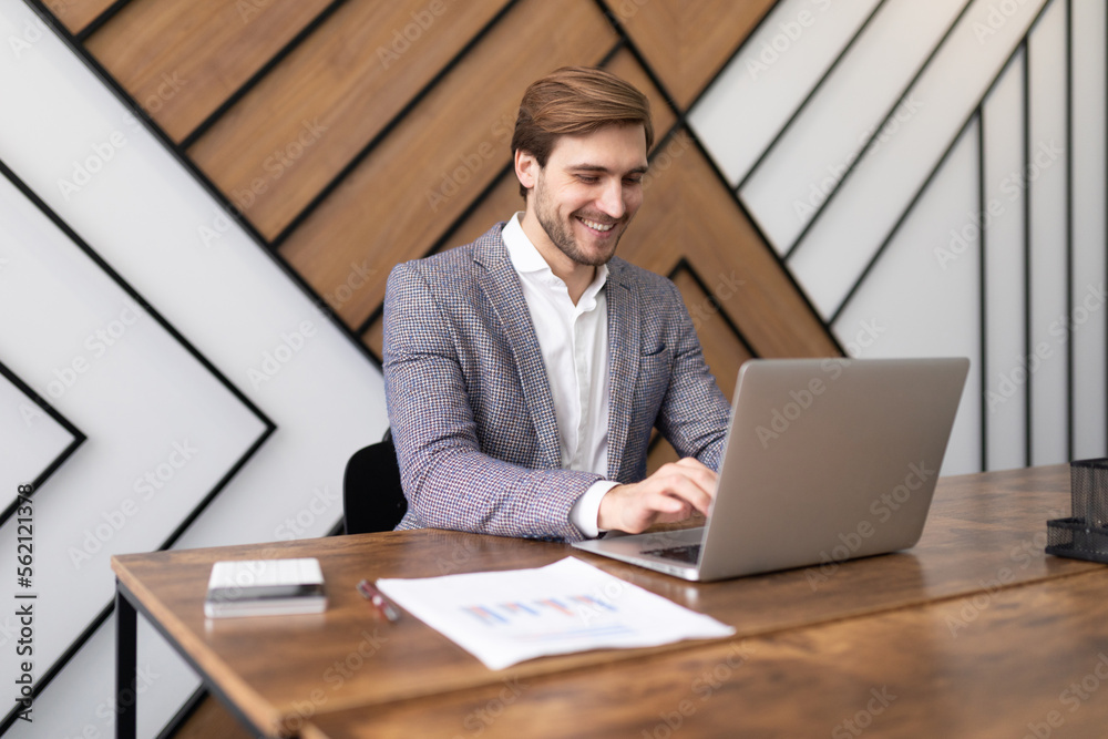 Fototapeta premium pretty successful businessman working in the office on a laptop