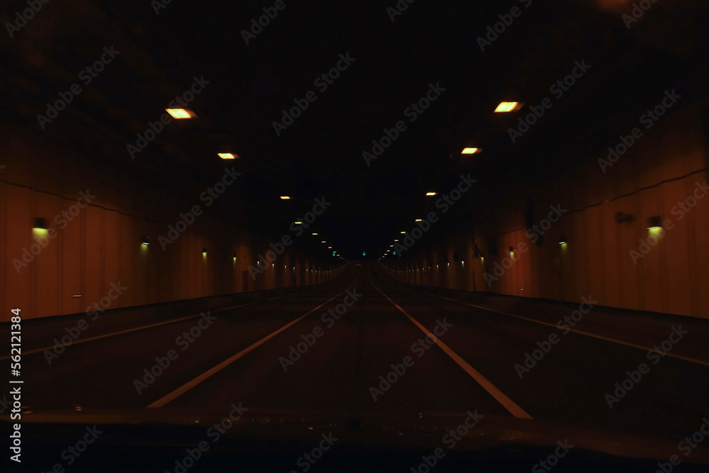 The car goes through a tunnel. Poverty view of drive at high speed through the tunnel to the light. Car fast in tunnel. View from a moving auto, underground.
