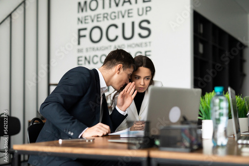 colleagues confer at meetings with partners whispering to each other on their thoughts