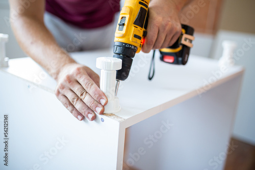 Male Using Self-Assembly Kit Making Cabinet