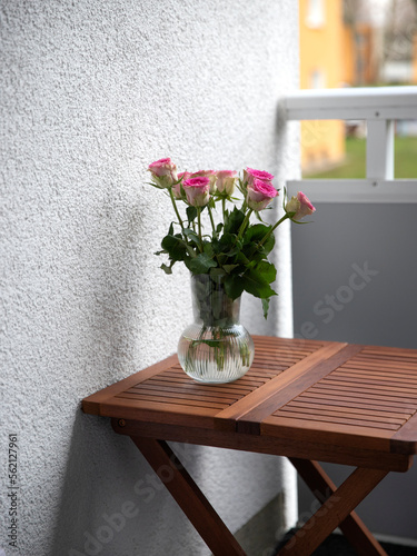 vase with roses on the table on the terrace