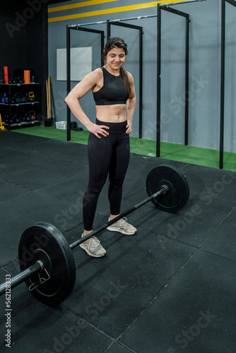 Young latina woman performing in weightlifting