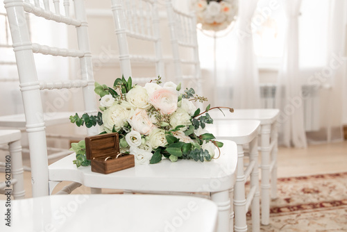 Wedding bouquet of white flowers and wedding rings. Details of the wedding ceremony.