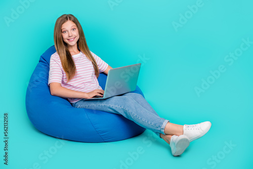 Full length photo of sweet lady wear t-shirt bean bag typing apple samsung device empty space isolated turquoise color background