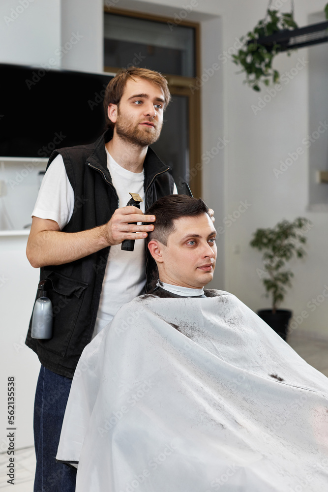 Barber shaving caucasian man in barber shop. Barber shaving caucasian man in barber shop.