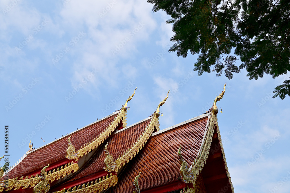 BANGKOK, THAILAND - January 16, 2023 : Part of the Roof of a temple in Thailand. Traditional Thai style pattern on the roof of a temple with Blue Sky Background.