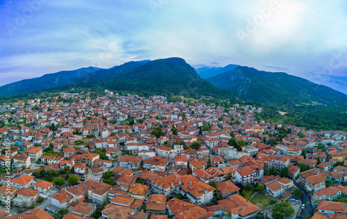Fototapeta Naklejka Na Ścianę i Meble -  Panorama of Greek town of Litochoro with small houses against the backdrop of the Mount Olympus and a cloudy sky