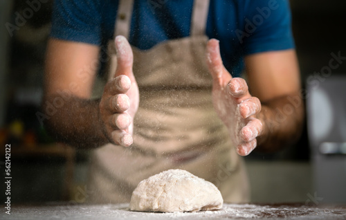 professional chef thresh flour white powder on wood table for sweet dessert cake and italian pizza in restaurant kitchen for special happy delicious dinner