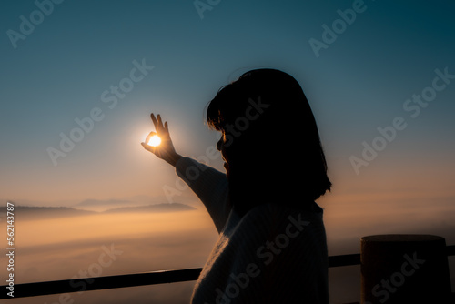 Hand gesture Ok with sun in the background