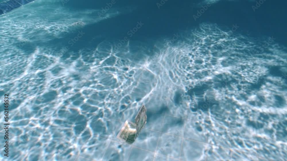 Banknote floats in the water. One dollar in the pool. Underwater photography. The banknote sinks to the bottom Banknote floats in the water. One dollar in the pool. Underwater photography. The banknote sinks to the bottom