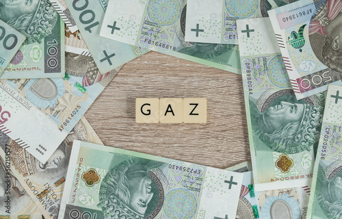 Gaz in Polish language means Gas. Energy crisis concept. Natural gas high cost. Rising gas price in Poland and rest of Europe. Flat lay with Polish złoty money, PLN zloty banknotes.