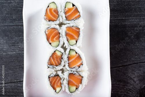 A top down view of a salmon and cucumber roll.