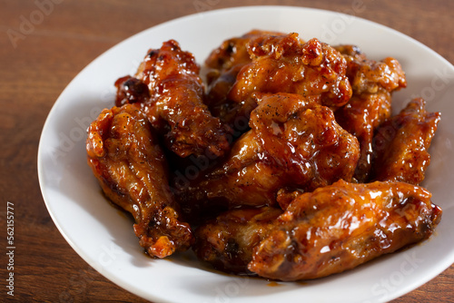A closeup view of a plate of glazed chicken wings.