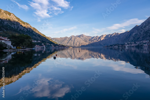 Panoramic view of bay of Kotor at sunrise in summer, Adriatic Mediterranean Sea, Montenegro, Balkans, Europe. Fjord winding along coastal towns. First sunbeams on Lovcen mountains. Water reflection © Chris