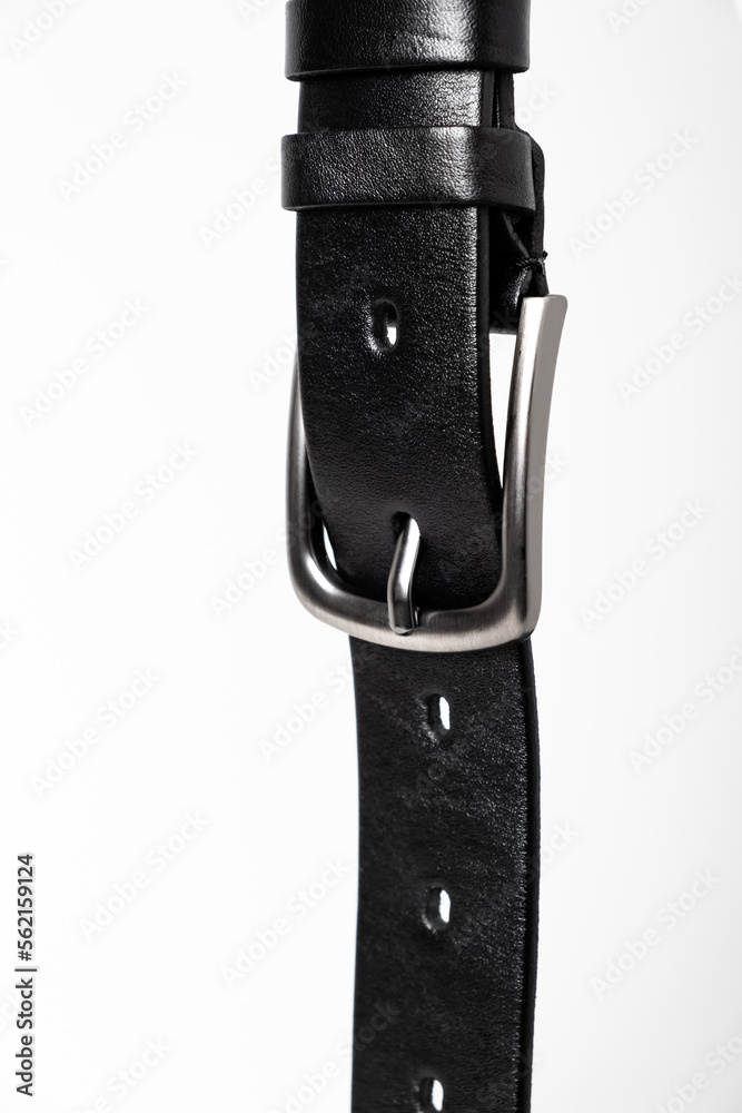 Black leather belt for trousers and jeans. Fastened fashionable men leather belt with dark chrome matted metal buckle isolated on white background. Male accessory. Luxury strap. Haberdashery goods