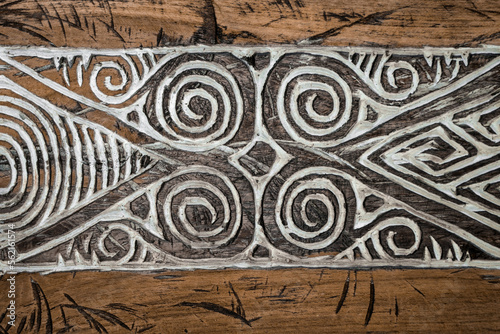 Balinese wood carving. A pattern of curls on the aged wood surface.