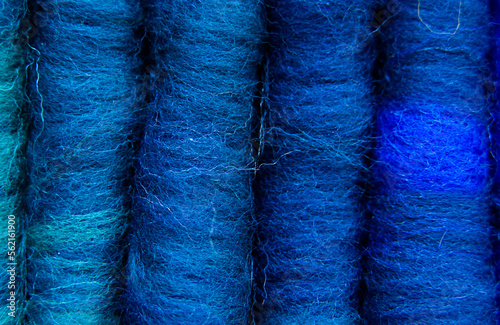 Close-up of a series of merino wool rolags in various shades of blue. Rolags are rolls of fibre such as wool, generally used to spin woollen yarn.