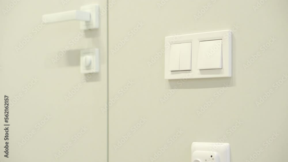 White switches and door handle in modern light interior. Close-up White switches and door handle in modern light interior. Close-up