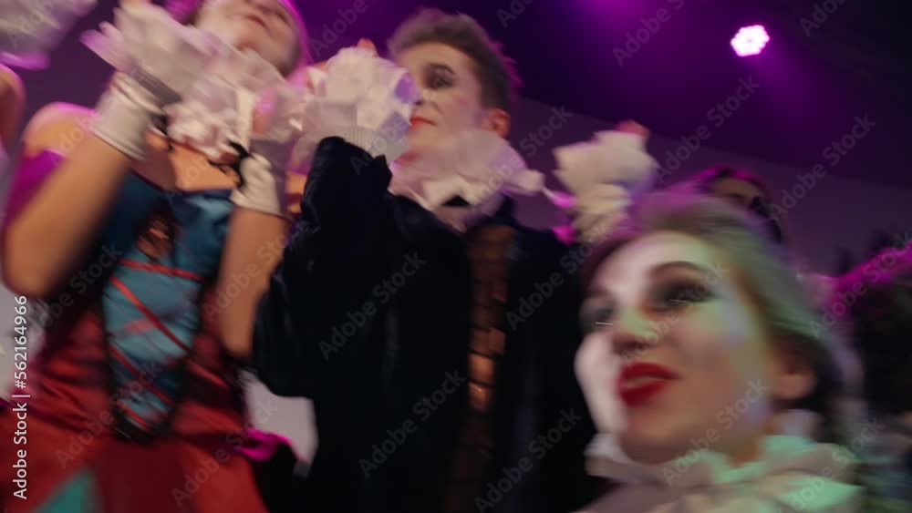 Group of curios excited actors and actresses clapping laughing watching acting on stage. Positive talented Caucasian men and women in retro-styled costumes playing in show in theater