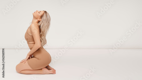 Young sexy blonde woman in underwear posing over white background