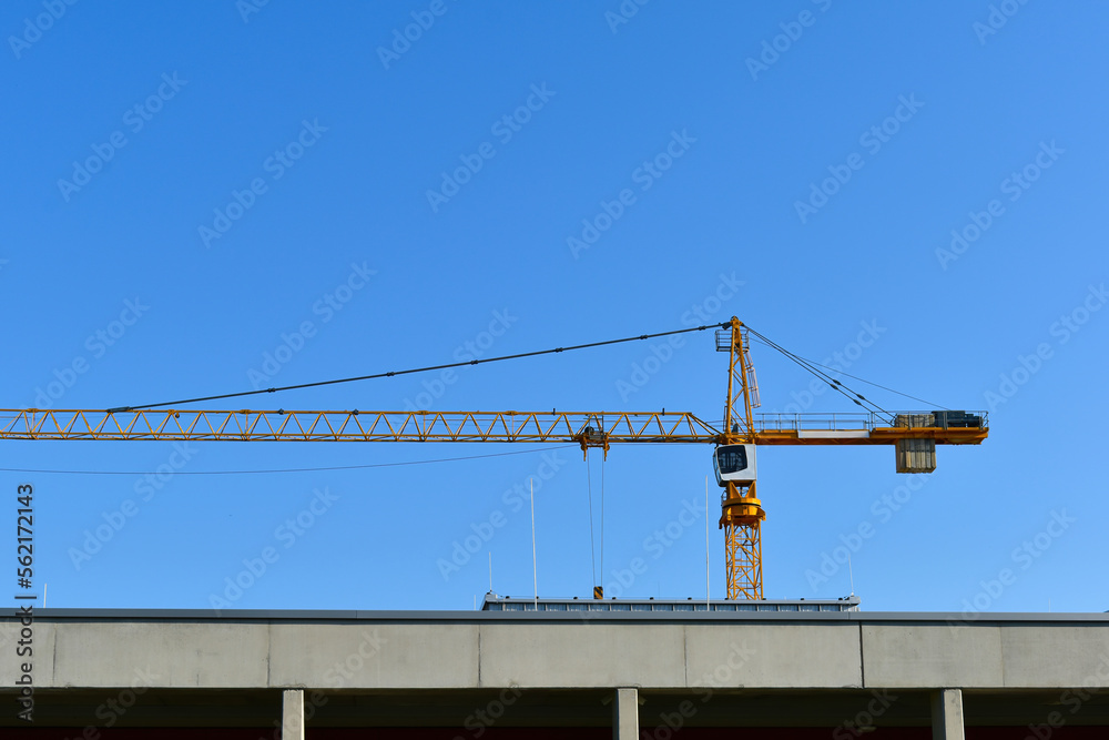 Yellow construction crane in a construction site. Building working machine. Yellow construction crane in a construction site. Building working machine.