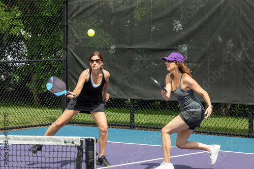 Two pickleball players prepare to hit a ball © pics721