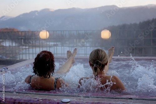 People, enjoying whirlpool and saunta after day of skiing, relaxing in nice warl whirlpool outdoor, splendid view photo