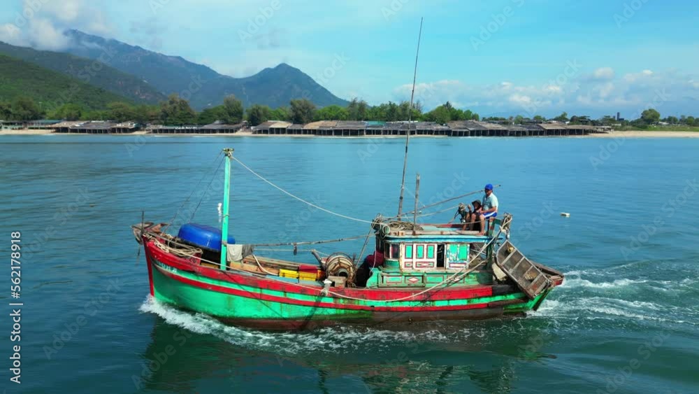 Fishermen Nha Trang in Vietnam are sailing on a against the backdrop of a beautiful landscape and a wonderful mountains on a sunny day. On sunny morning, fishing boat hurries to sea to catch seafood Fishermen Nha Trang in Vietnam are sailing on a against the backdrop of a beautiful landscape and a wonderful mountains on a sunny day. On sunny morning, fishing boat hurries to sea to catch seafood