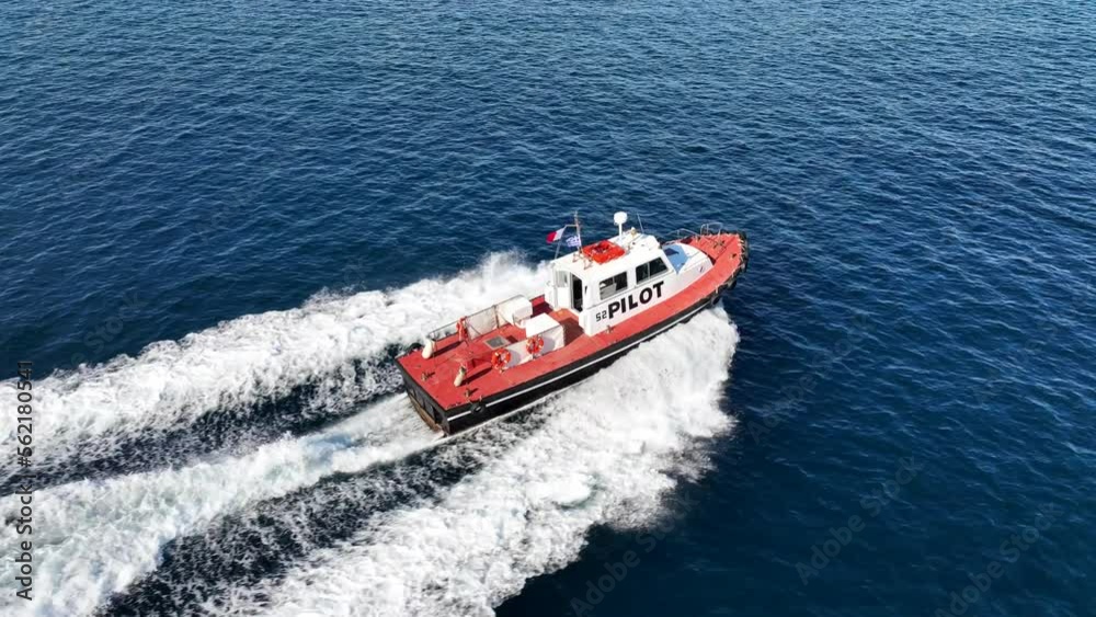 Aerial drone tracking video of red pilot boat cruising in high speed in Mediterranean deep blue sea offering navigational aid to ships Aerial drone tracking video of red pilot boat cruising in high speed in Mediterranean deep blue sea offering navigational aid to ships