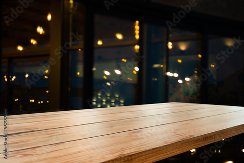 Empty workplace, table on the background of blurred cafe lights