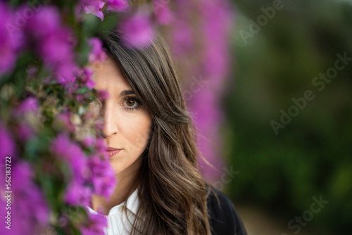 Portrait of a sad woman near some violet flowers