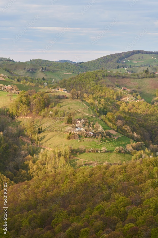 Amazing spring countryside landscape, houses and farmlands on the hills.