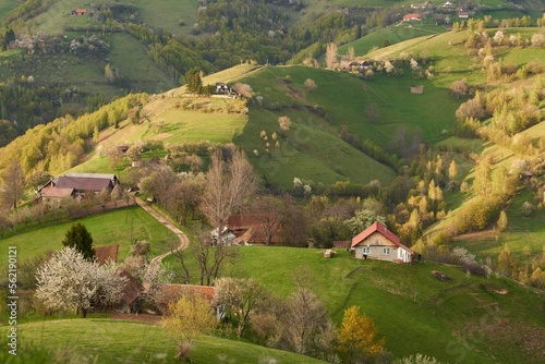 Amazing spring countryside landscape, houses and farmlands on the hills.