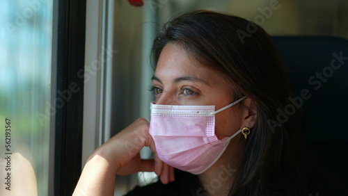 Passenger in train wearing covid face mask. Woman riding transportation with surgical mask
