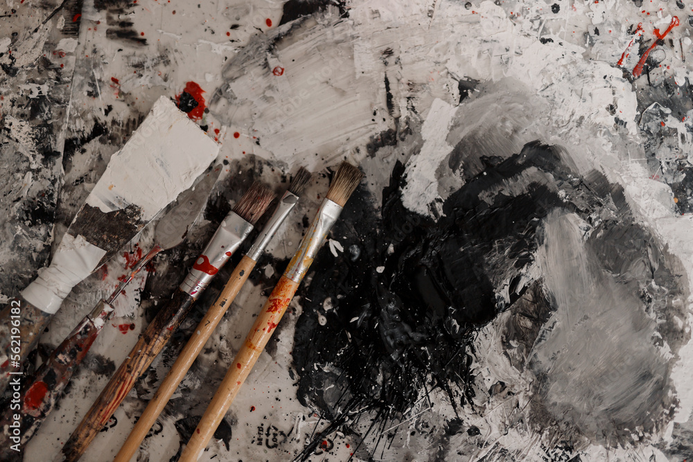 Obraz premium Artist brush mixed color oil painting on palette. Macro artist's palette. Palette with paintbrush. Artist paints a picture of oil paints. Art palette