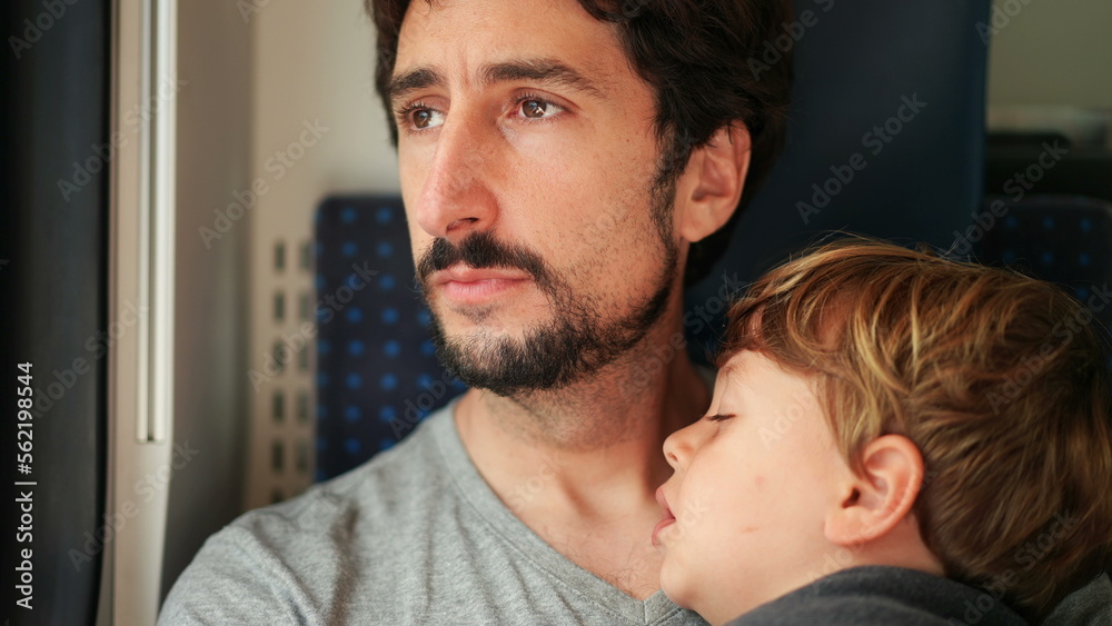 Loving pensive father holding sleep child traveling by train. Dad kissing son forehead Loving pensive father holding sleep child traveling by train. Dad kissing son forehead