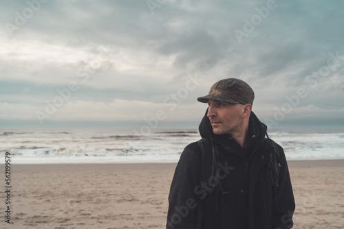 Mann am Strand mit dem Rücken zum Meer schaut sich um © Jonas Wakewood