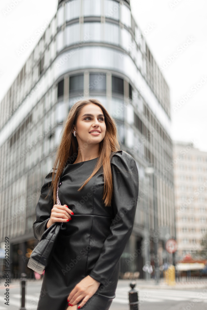 Happiness urban business beauty woman in elegant fashion black dress with bag walks in the city
